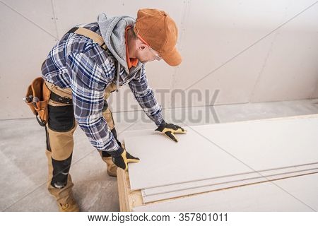 Construction Worker Preparing Building Materials. Drywall, Sheetrock And Plywood Boards. Constructio