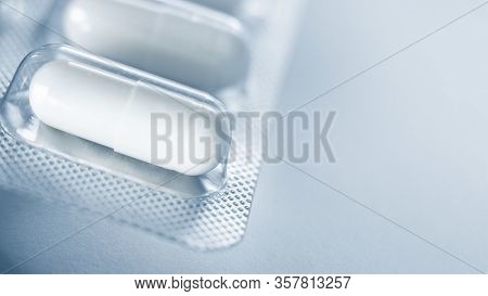 One Blister Of Pills Macro. Oval Long Shape Remedies. Blue Tone, Sun Fleck. Background Or Texture Ab