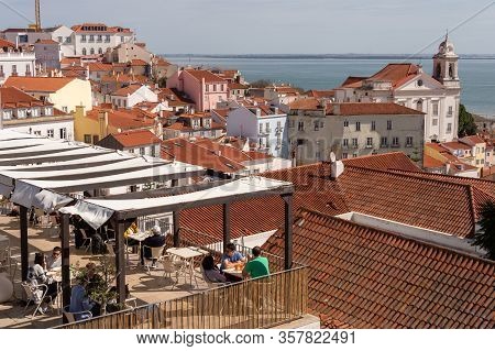 Lisbon, Portugal 8 March 2020: People Having A Dring At A Terrace Bar With Lisbon Skyline In Backgro