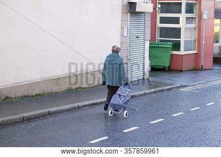 Social Distancing Lone Venerable Senior Woman Shopper In Street Due To Coronavirus Uk