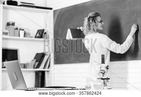 Student Girl Writing Answer At Blackboard. Beaker And Microscope. Student Doesnt Use Laptop. Biology
