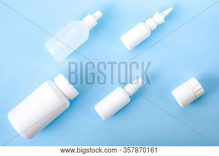 Various White Plastic Medical Containers Set On Light Blue Background. Virus Or Flu Or Cold Treatmen