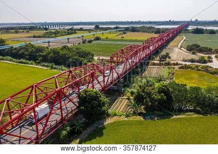 red famous Xilou Bridge over the river and farm in Yunlin county, Taiwan