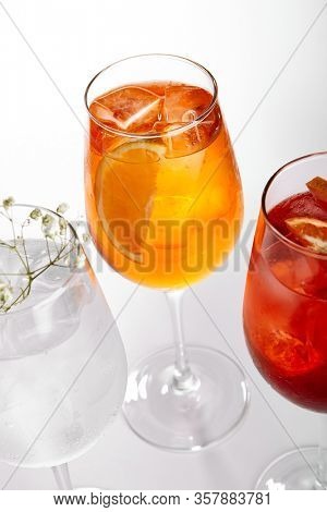 Spritz fruit cocktails. Alcohol soft drinks in glasses side view. Refreshment beverage with coconut, berry, orange in drinkware. Exotic summer beach cocktail portions with crushed ice in glassware