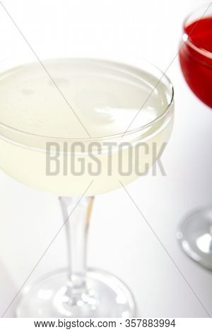 Tropical daiquiri cocktail close up. Alcohol strong drink in glass side view. Beverage with rum and fruit juice in drinkware. Summer beach exotic cocktail portion with crushed ice in glassware