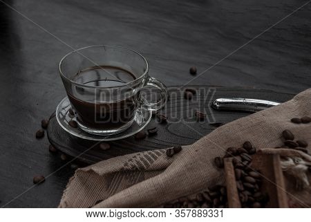 Coffee Style, Cup Of Coffee And Coffee Beans Roating With Old Wooden Scoop And Coffee Beans Around O