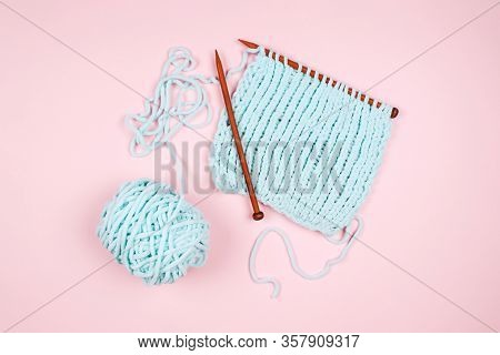 Mentol Yarn Ball And Wodden Knitting Needle On Light Pink Background