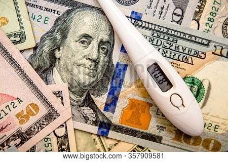 A Hundred-dollar Bill With A Thermometer.the Concept Of Coronavrius Epidemic