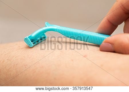 Close Up Picture Of Woman Holding Razor, Shaving Her Hairy Leg With Folliculitis