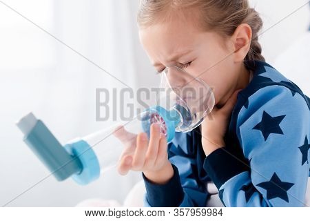Sick Kid With Closed Eyes Using Inhaler With Spacer