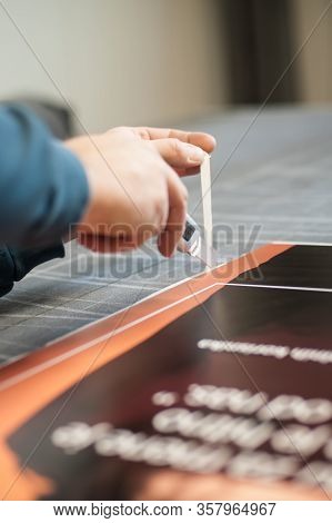 Close-up Of Hand With Skalpel. Worker Cut Paper In Printshop