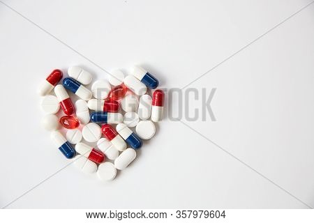 Heart Pills, Tablets, Statins And Drugs Arranged Into The Shape Of A Heart On A White Background Wit