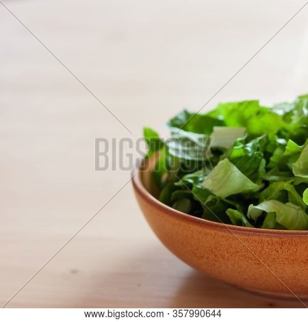Green Salad Of Lattuce In Natural Ceramic Plate On Wooden Light Background. Space For Text. Healthy 