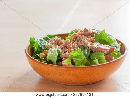 Green Salad Of Lattuce With Tuna And Chickpeas In Natural Ceramic Plate On Wooden Light Background. 