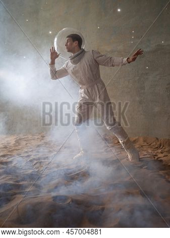 Fear Of The Unknown On Alien Planets. An Astronaut In A White Spacesuit Walks Through An Abandoned C