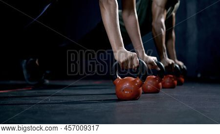 Athletic Woman And Man With Kettlebell Dumbbell During Cross Training At Fitness Gym. Health And Mus