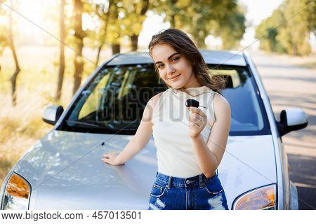 Attractive Female Driver With Car Key Near New Modern Car. Proud Student Earned Money And Bought New