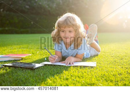 Cute Childr Boy Writing Notes In Copybook Outdoors. Summer Camp. Kids Learning And Education Concept