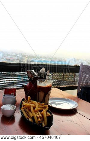 Cold Coffee And Potato Fries Served On A Restaurant Table. Snacks Served In A Restaurant With The Sk