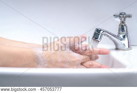 Woman Washing Hand With Soap Foam And Tap Water In Bathroom. Hand Clean Under Faucet On Sink For Per