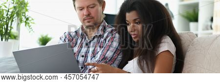 Portrait Of Middle Aged Man And Latino American Woman Choosing Something Online. Couple Want To Buy 
