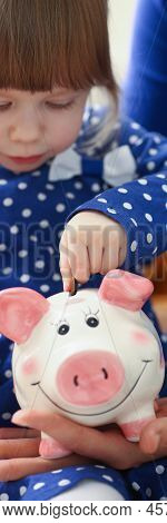 Portrait Of Cute Little Child Putting Coin Cash Into Piggy Bank Container. Mother Teach Daughter To 