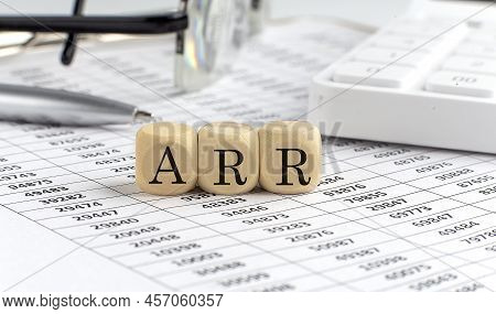 Wooden Cubes With The Word Arr On Financial Background With Chart, Calculator, Pen And Glasses, Busi