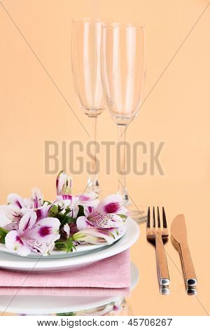 Impostazione tavolo festivo con fiori su sfondo peachy