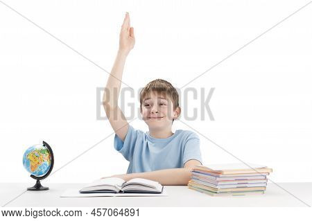 Schoolboy Raised His Hand During The Lesson. Excellent Student Knows The Answer. Portrait Of Boy At 