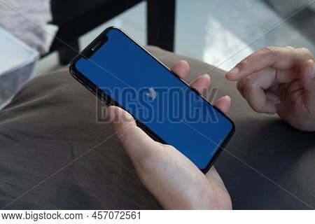 Chiang Mai, Thailand - Feb.12, 2022: Woman Holding Apple Iphone X With Twitter Application On The Sc