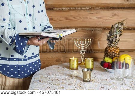 A Jewish Woman Prays The Siddur Kabalat Shabbat After Lighting Candles.