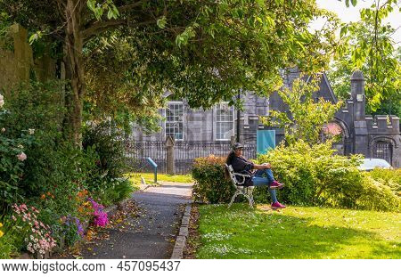 Limerick, Ireland - June 4, 2022: A Woman Resting In The Beautiful Garden  Near St. Mary\'s Cathedra