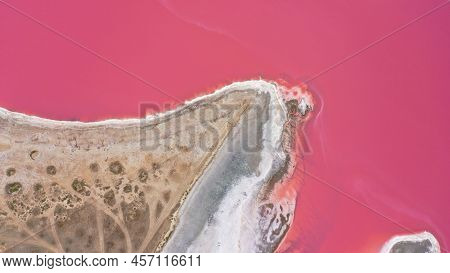 Flying Over A Pink Salt Lake. Salt Production Facilities Saline Evaporation Pond Fields In The Salty