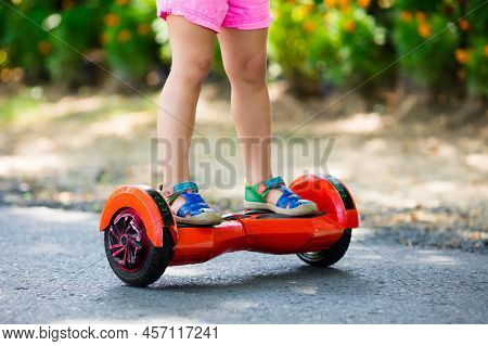 Child On Hover Board. Kids Riding Scooter In Summer Park. Balance Board For Children. Electric Self 