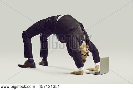 Happy Flexible Businessman In Suit Doing Yoga While Working On His Laptop Computer