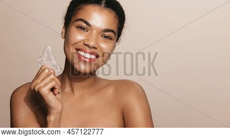 Smiling African American Woman Holds Gua Sha Scrapper Tool For Facial Lifting, Tcm Face Cosmetic Tre