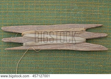 One Gray Wooden Board With A Wound White Fishing Line Lies On A Green Table Cloth