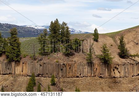 Red Rock Cliffside With Trees In American Landscape. Yellowstone National Park. United States. Natur