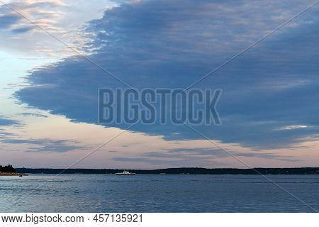 Dusk On Cape Cod, Massachusetts With Large Clouds In Blue Hues.