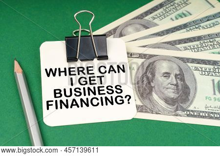 Business Concept. On A Green Surface, A Pen, Dollars And In A Clip Paper With The Inscription - Wher
