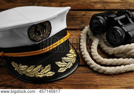 Peaked Cap And Rope With Binoculars On Wooden Background, Closeup