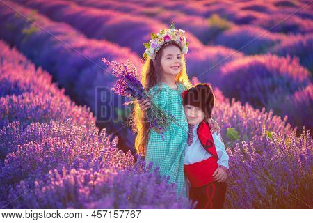 Portrait Of Children Boy And Girl In Traditional Bulgarian Folklore Costume In Lavender Field During