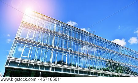 Modern Office Building With Glass Facade On A Clear Sky Background. Transparent Glass Wall Of Office