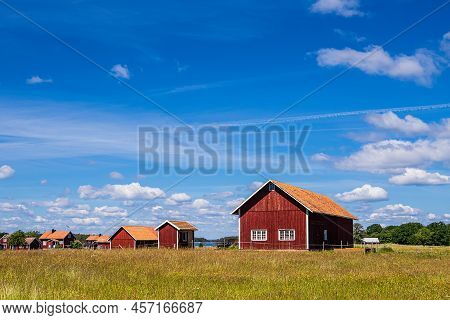 Red Wooden Building On The Island Sladö In Sweden.