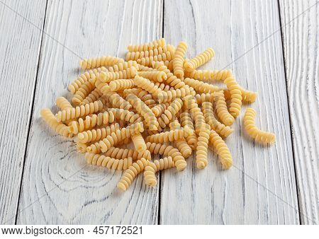 Uncooked Fusilli Pasta On White Wooden Background