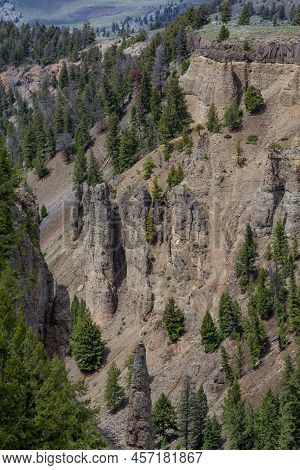 Red Rock Cliffside With Trees In American Landscape. Yellowstone National Park. United States. Natur