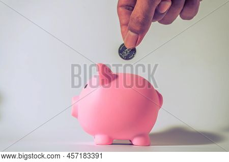 Save Money And Account Banking For Finance Concept, Hand With Piggy Bank And Coin On Blurred Backgro