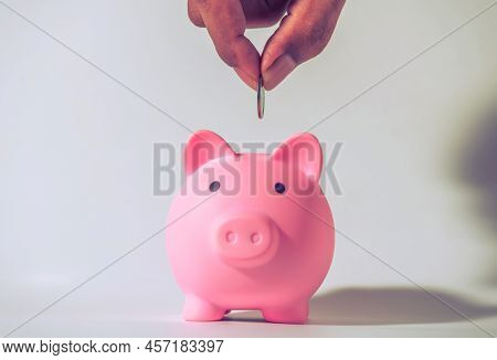 Save Money And Account Banking For Finance Concept, Hand With Piggy Bank And Coin On Blurred Backgro