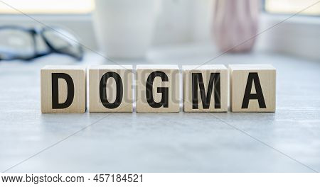 Dogma Text On The Wooden Block With Notebooks , Keyboard With Chart.