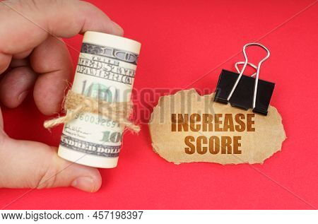 Business Concept. The Man Has Dollars In His Hands, On A Red Surface There Is A Cardboard Sign With 